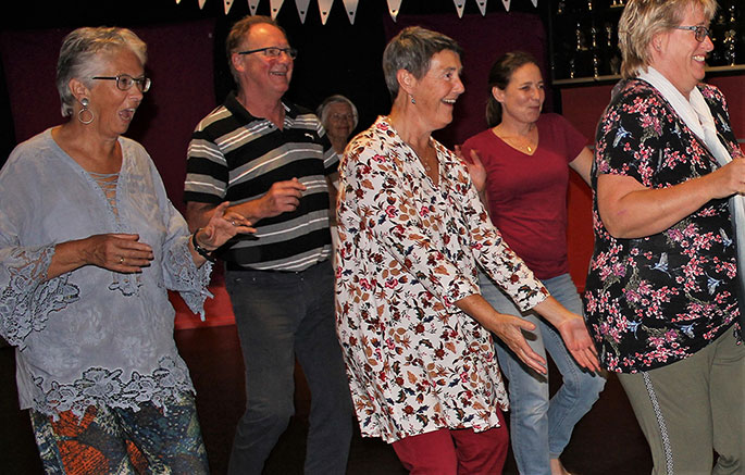 Vrolijk dansende deelnemers in workshop biodanza